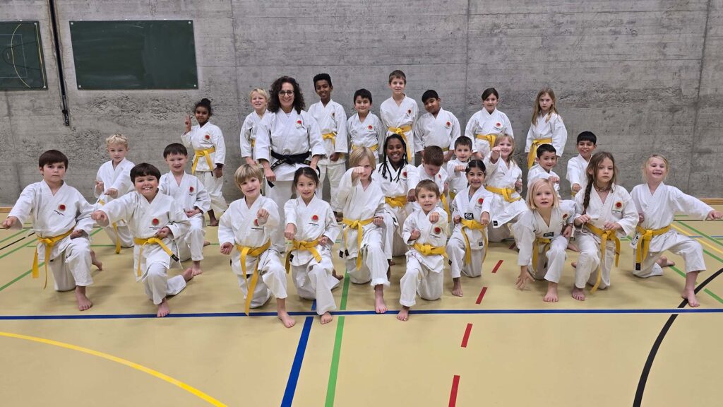 Karate Kinder der Gruppe 2 mit Instruktorin nach der erfolgreich bestandenen Karate-Prüfung in Aarau an der Kampfsportschule Aarau (karateschule.ch). Grosse Freude für die Kinder.