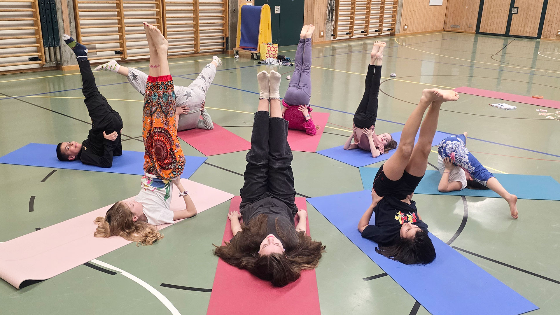 Die Yoga-Kids der Kampfsportschule Aarau üben die Kerze (Sarvangasana), die sie kreativ weiterentwickeln.